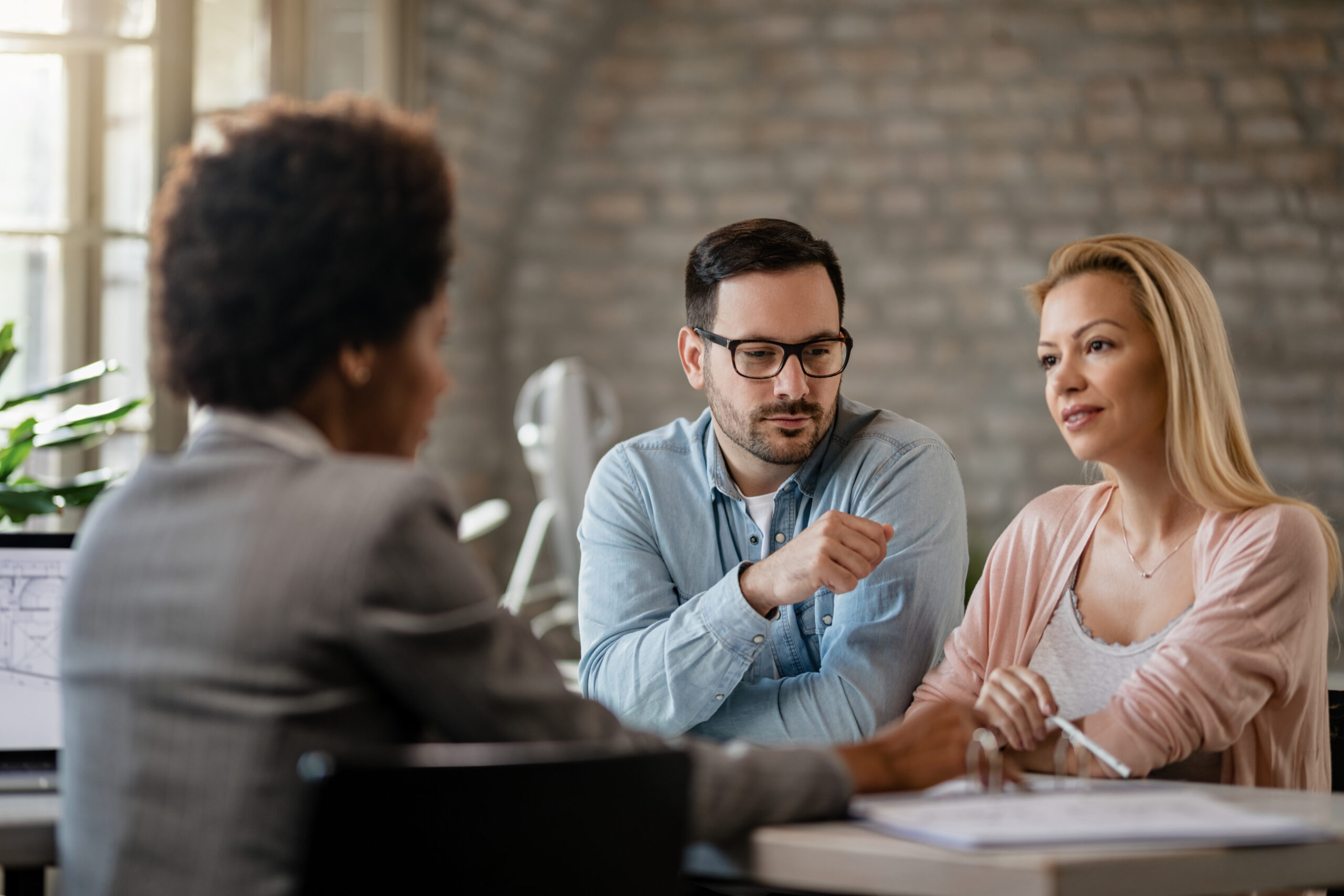Couple communicating with their insurance agent on a meting in t